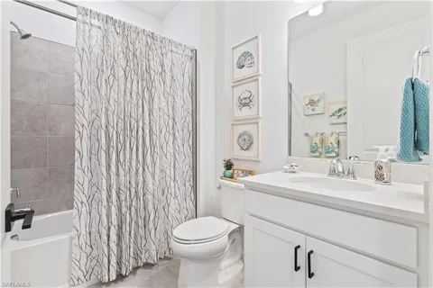 a bathroom with a sink a toilet and shower curtain