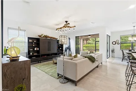 a bedroom with furniture a flat screen tv and a large window