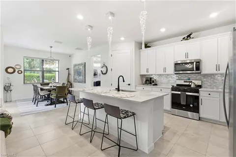 a kitchen with appliances a sink a counter top space and a center island
