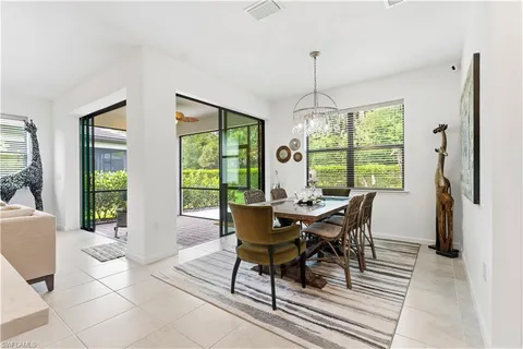 a dining room with furniture a chandelier and wooden floor