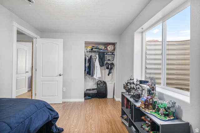 860 West 2980th Street South Logan, UT 84321 - Photo 29 of 38 Bright bedroom featuring wood-finish flooring, a white window frame, and light gray walls