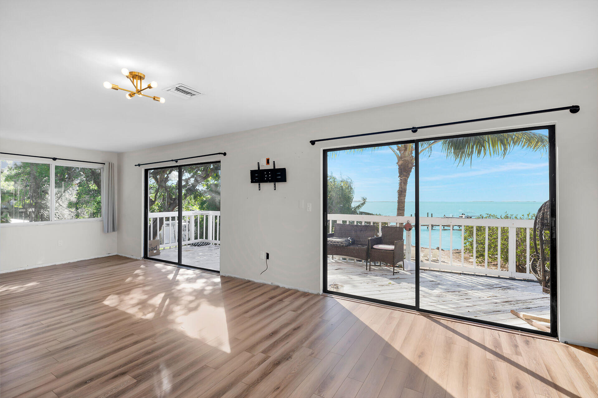 100 Point Pleasant Drive Key Largo, FL 33037 - Photo 18 of 32 a view of an empty room with wooden floor and a window