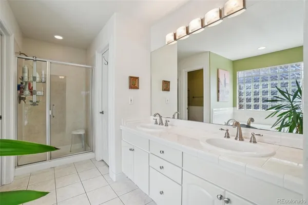 a bathroom with a double vanity sink mirror and shower