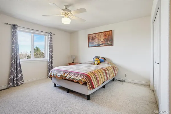 a bedroom with a bed and painting on the wall