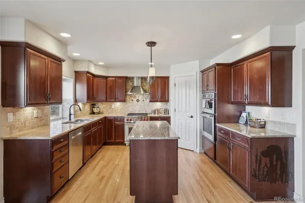 a large kitchen with stainless steel appliances lots of counter space and a sink