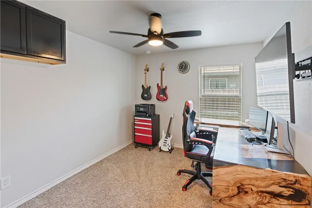 a view of a workspace with furniture and a window