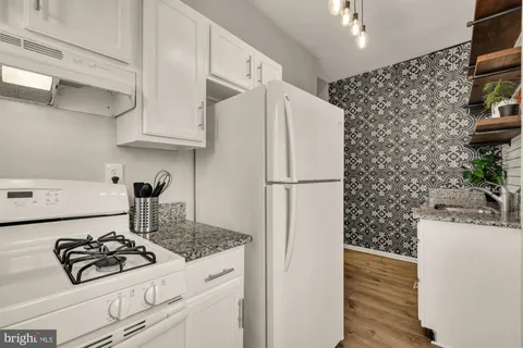 a kitchen with stainless steel appliances granite countertop a refrigerator and a stove