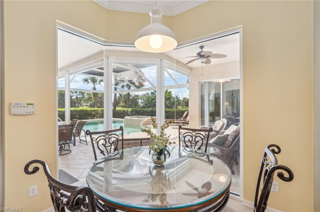 11446 Stratham Loop Estero, FL 33928 - Photo 11 of 27 a dining room with wooden floor a chandelier a glass table and chairs