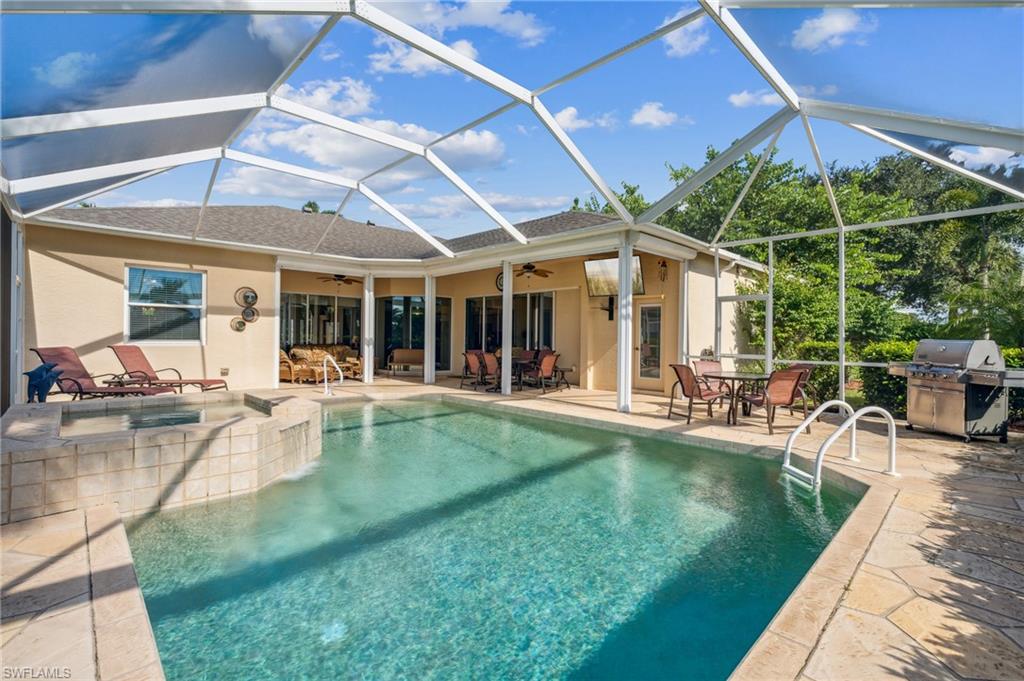 11446 Stratham Loop Estero, FL 33928 - Photo 2 of 27 a view of a swimming pool with table and chairs under an umbrella