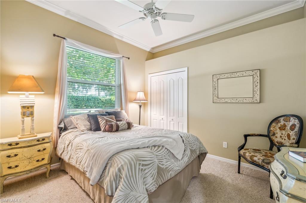 11446 Stratham Loop Estero, FL 33928 - Photo 22 of 27 a bedroom with a bed and a chandelier