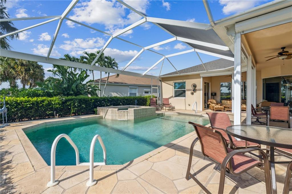 11446 Stratham Loop Estero, FL 33928 - Photo 3 of 27 a view of a swimming pool with a table and chairs in patio