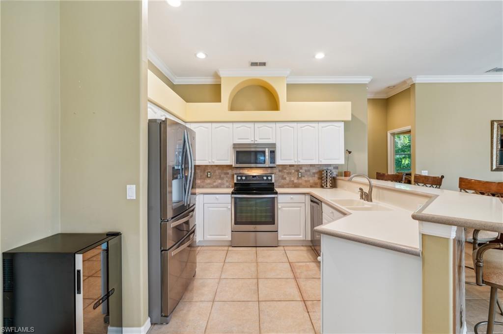 11446 Stratham Loop Estero, FL 33928 - Photo 9 of 27 a kitchen with a sink a stove top oven and cabinets