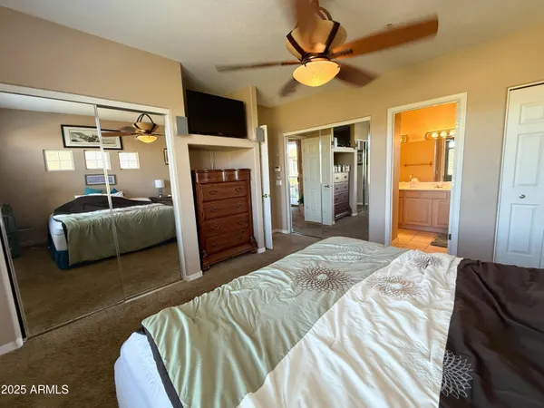 a bedroom with a bed mirror and a flat tv screen