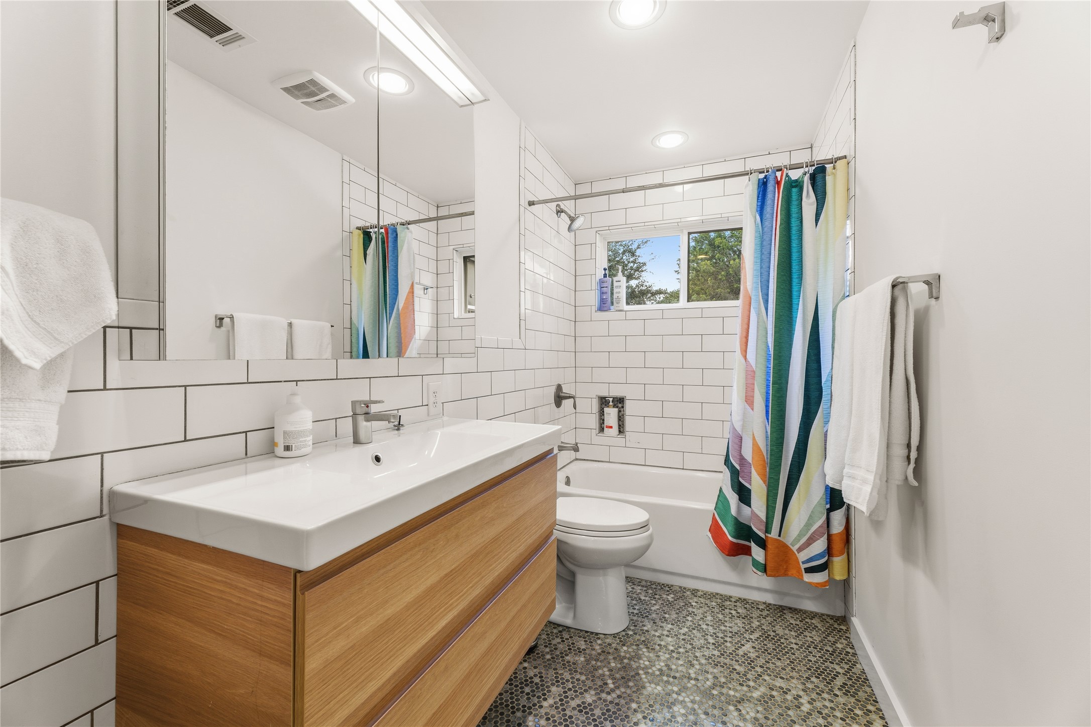 12901 Wire Road Leander, TX 78641 - Photo 14 of 40 Modern tile surrounds a clean vanity cabinet and sleek fixtures in this remodeled bathroom.