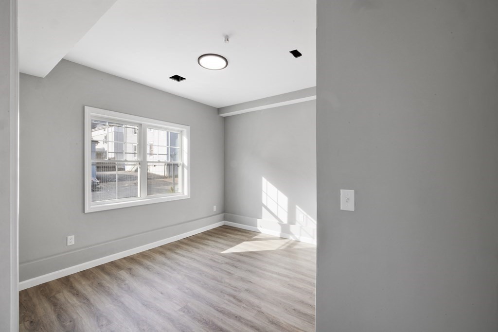 550 Spring Street, Unit 2 Fall River, MA 02721 - Photo 17 of 23 a view of an empty room with wooden floor and a window