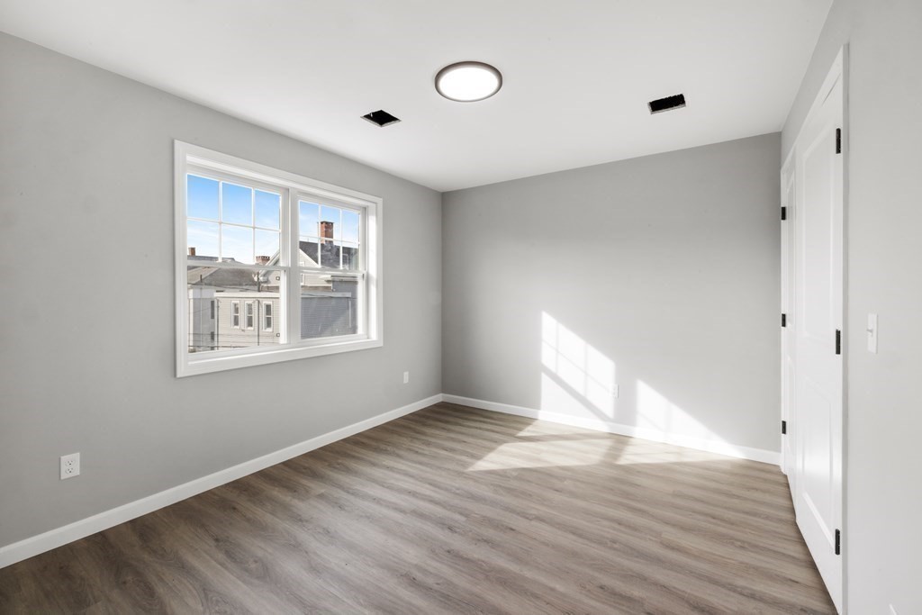 550 Spring Street, Unit 2 Fall River, MA 02721 - Photo 21 of 23 a view of an empty room with wooden floor and a window
