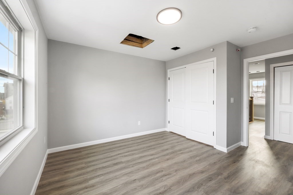 550 Spring Street, Unit 2 Fall River, MA 02721 - Photo 22 of 23 an empty room with wooden floor and windows
