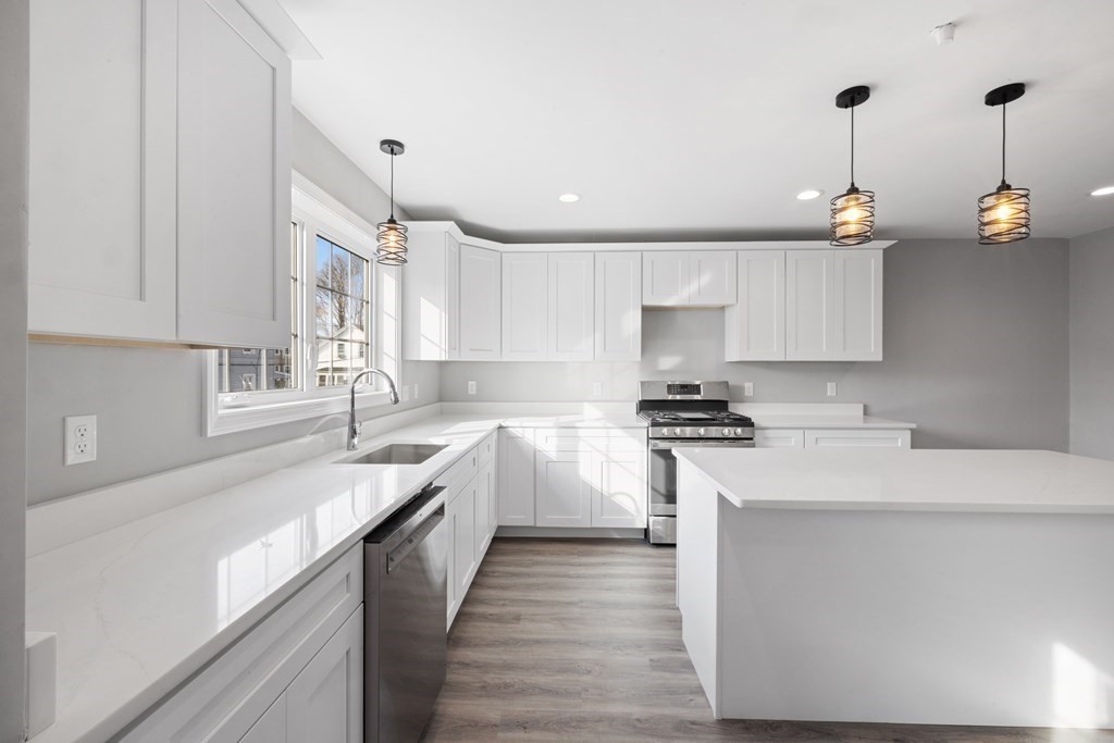 550 Spring Street, Unit 2 Fall River, MA 02721 - Photo 4 of 23 a kitchen with a sink white cabinets and white appliances
