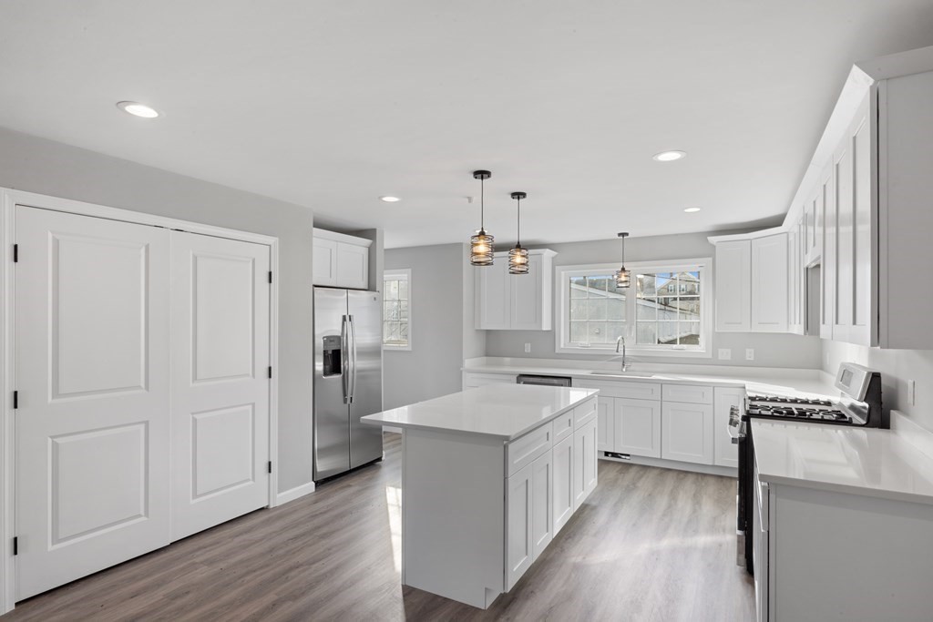 550 Spring Street, Unit 2 Fall River, MA 02721 - Photo 7 of 23 a large kitchen with lot of cabinets and wooden floor