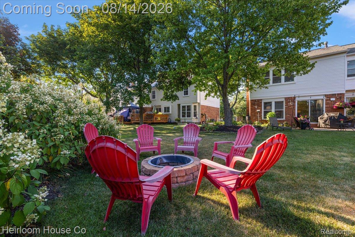 45697 Bryn Mawr Road Canton, MI 48187 - Photo 5 of 75 Expansive backyard featuring a central brick fire pit, manicured lawn, and mature trees