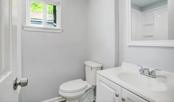 a bathroom with a sink a toilet and a window