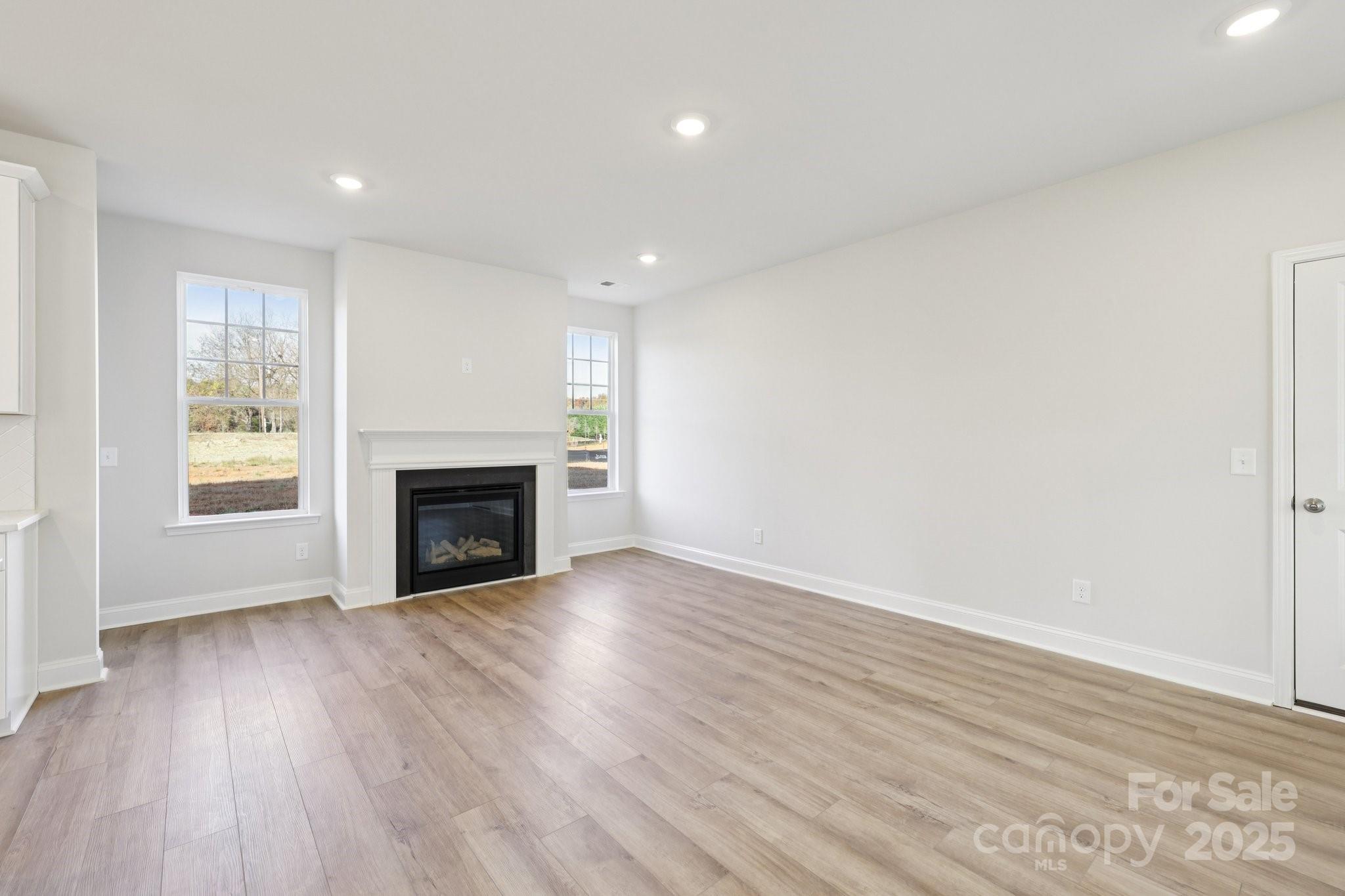 9612 Pointer Road, Unit 59 Huntersville, NC 28078 - Photo 8 of 43 a view of an empty room with wooden floor fireplace and a window