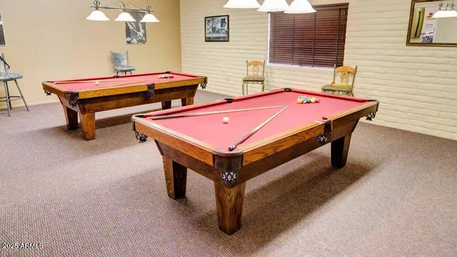 a room with pool table and windows