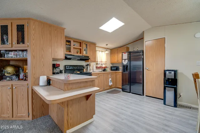 a kitchen with stainless steel appliances granite countertop a refrigerator a stove top oven a sink and dishwasher