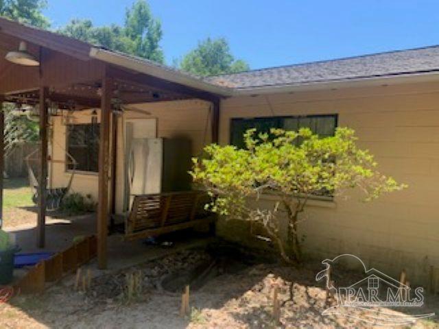 4165 Highway 87 Navarre, FL 32566 - Photo 2 of 4 a backyard of a house with lots of green space and glass windows