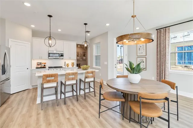 a dining room filled chandelier and wooden floor
