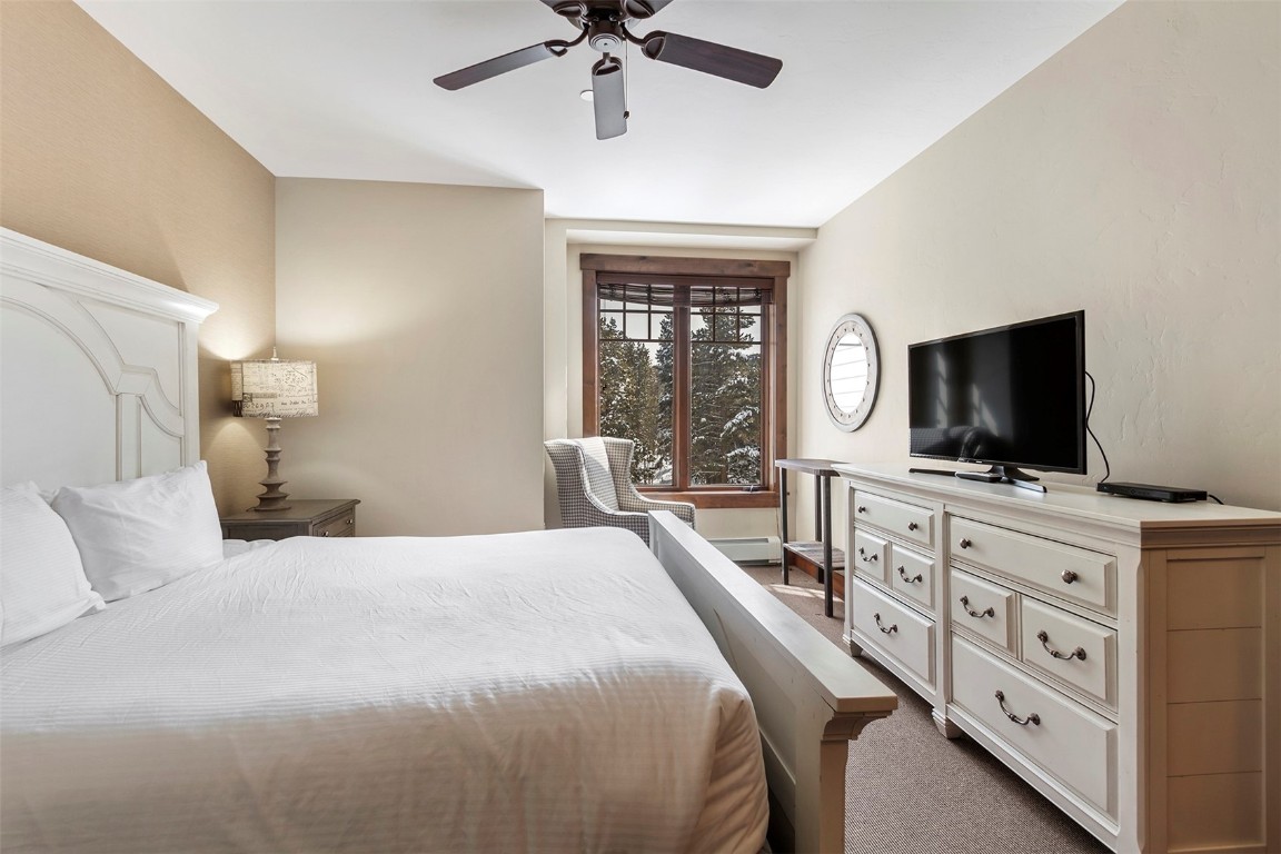 610 Columbine Road, Unit 6308 Breckenridge, CO 80424 - Photo 16 of 49 a bedroom with a large bed and a flat tv screen on dresser