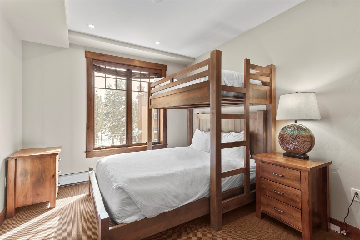 610 Columbine Road, Unit 6308 Breckenridge, CO 80424 - Photo 22 of 49 a bedroom with a bed and wooden floor