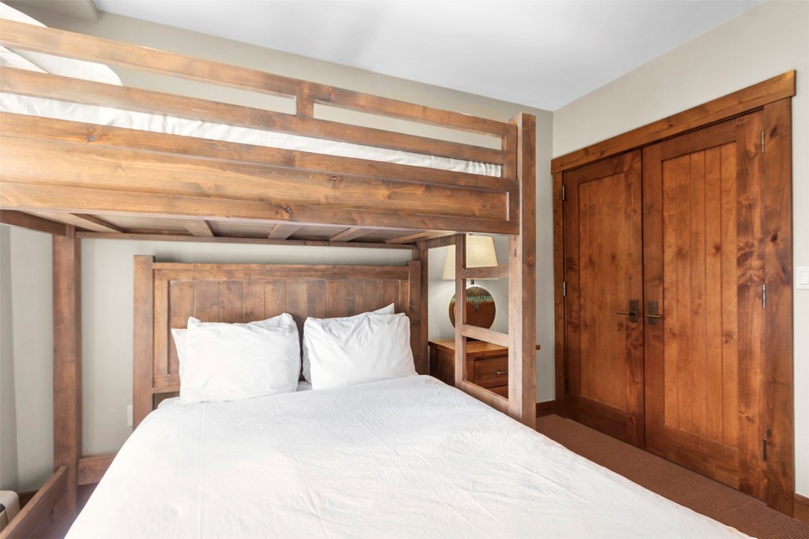 610 Columbine Road, Unit 6308 Breckenridge, CO 80424 - Photo 23 of 49 a bedroom with a large bed and a closet with wooden floor