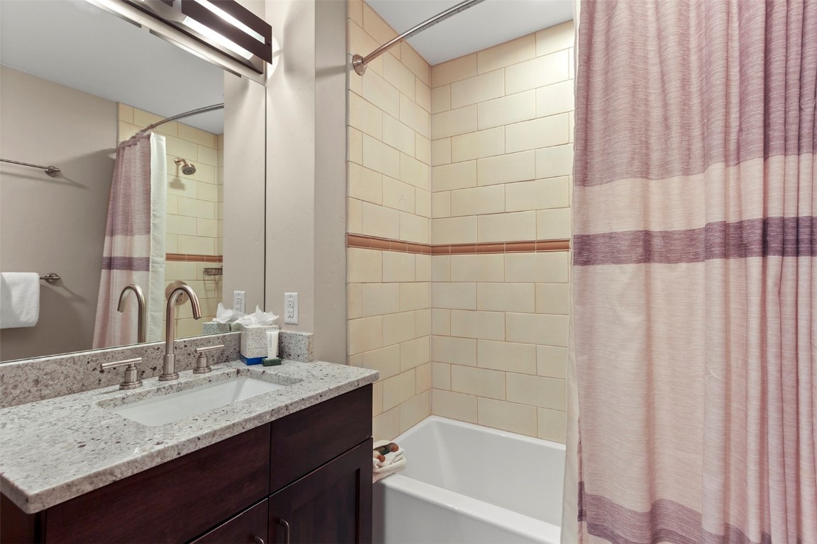 610 Columbine Road, Unit 6308 Breckenridge, CO 80424 - Photo 24 of 49 a bathroom with a granite countertop sink and a mirror