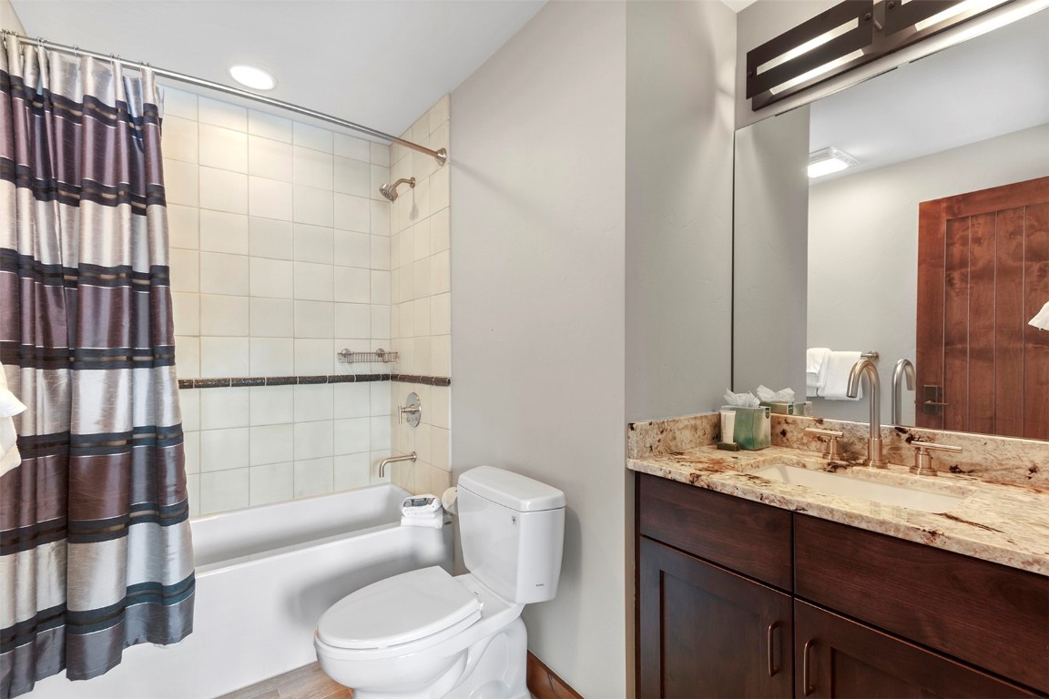 610 Columbine Road, Unit 6308 Breckenridge, CO 80424 - Photo 27 of 49 a bathroom with a granite countertop sink toilet a shower and a mirror
