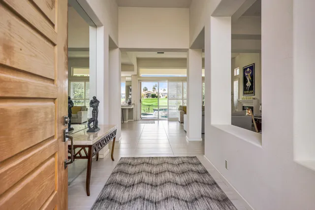 a view of a hallway to a livingroom with furniture and floor to ceiling window