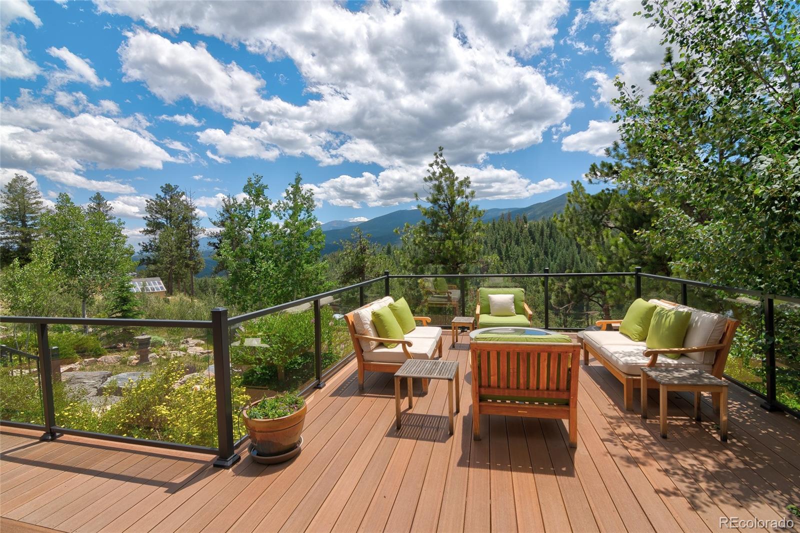 682 Buddy Road Bailey, CO 80421 - Photo 13 of 50 a view of a roof deck with table and chairs with wooden floor and fence
