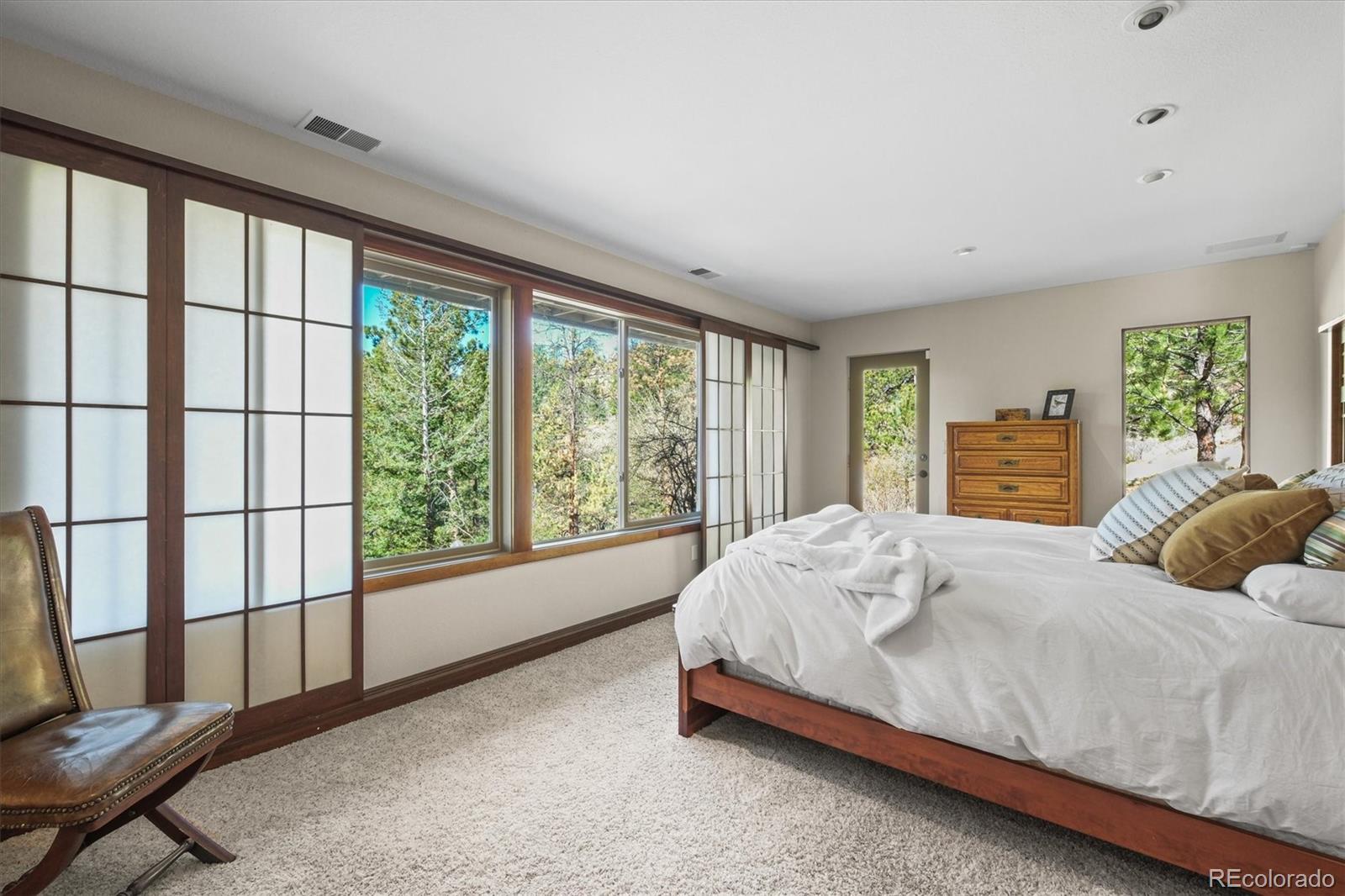682 Buddy Road Bailey, CO 80421 - Photo 27 of 50 a bed sitting in a spacious bedroom next to a window