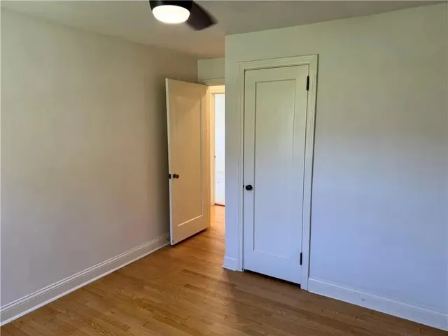 an empty room with a window and wooden floor