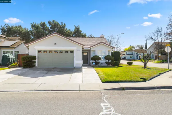 a front view of a house with a yard and trees