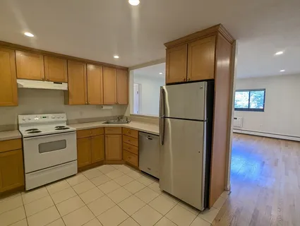a kitchen with a refrigerator sink and cabinets