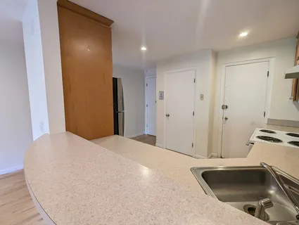 a view of a kitchen with a sink and stainless steel appliances granite floor to ceiling window