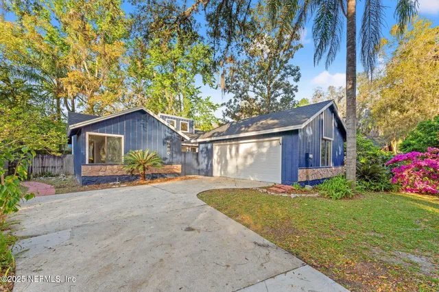 a view of a house with a yard and potted plants