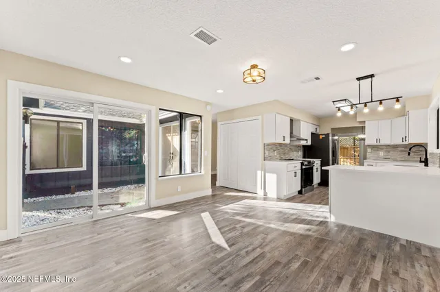 a view of a kitchen with furniture and wooden floor