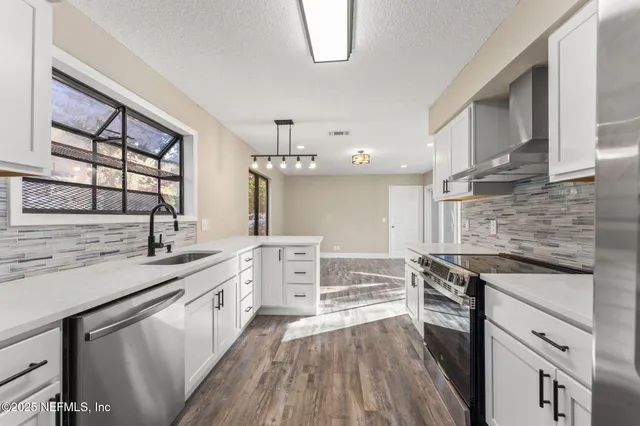 a kitchen with stainless steel appliances a stove sink and cabinets