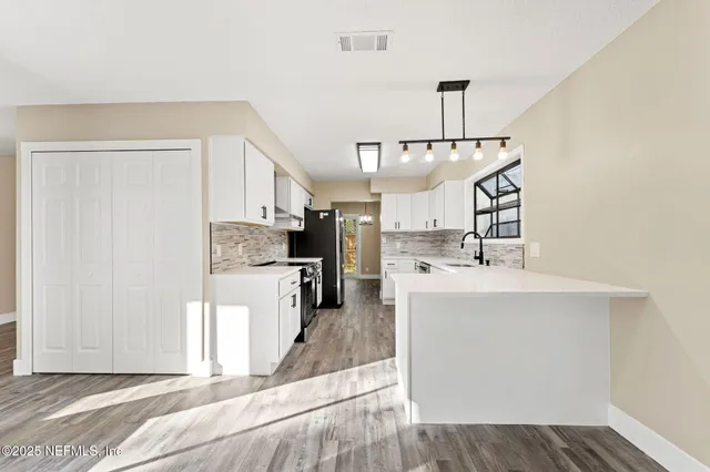 a kitchen with stainless steel appliances kitchen island a refrigerator sink and stove