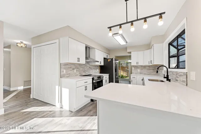 a kitchen with a refrigerator a sink and cabinets