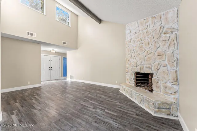 a view of empty room with wooden floor and fireplace