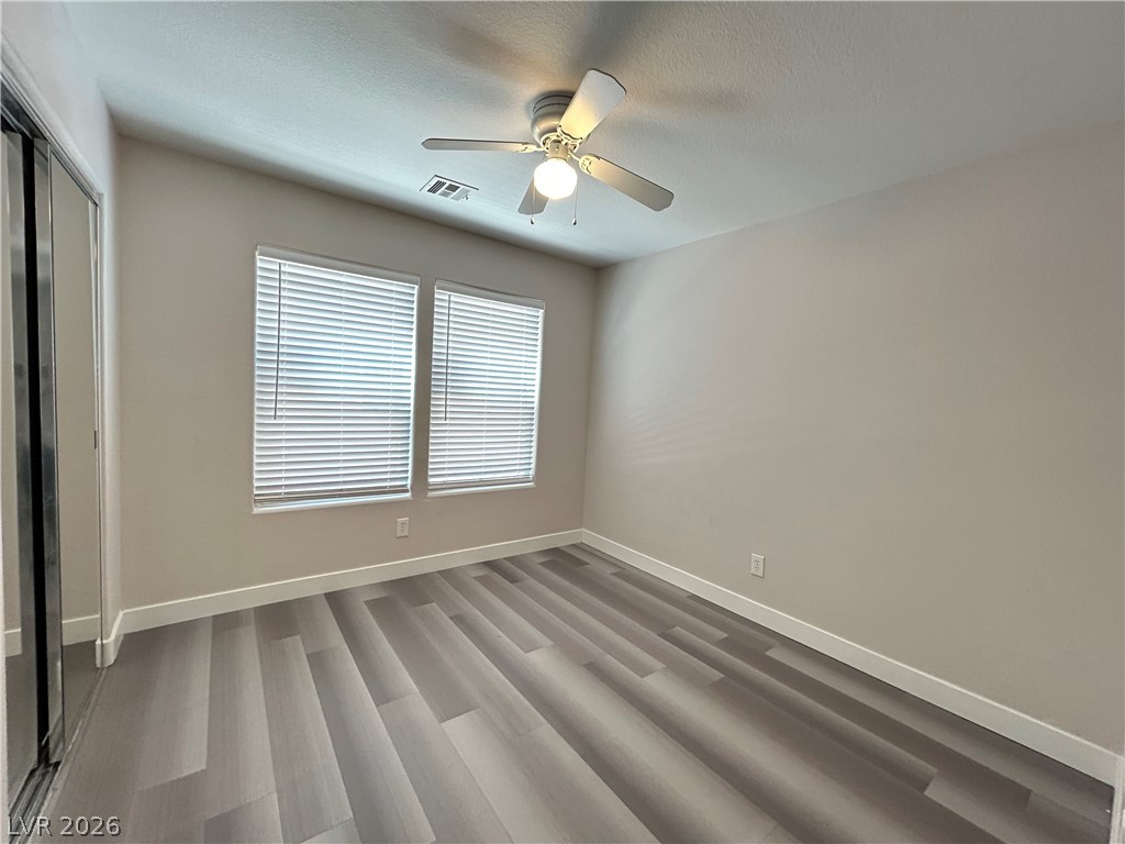 6538 Elm Spring Las Vegas, NV 89148 - Photo 19 of 29 Newly installed wide plank flooring and a modern ceiling fan elevate this tranquil sleeping space.