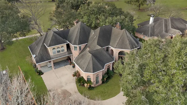 an aerial view of a house with outdoor space and a lake view in back